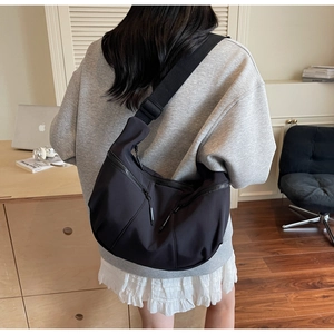 Détails du sac bandoulière croissant en nylon noir avec plusieurs poches zippées