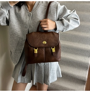 Detail of vintage brown leather backpack with gold hardware and stylish flap closure