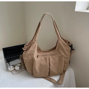Spacious khaki nylon tote bag featuring functional external pockets and adjustable side buckles