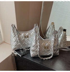 Detail of silver quilted handbags with metal chain straps and classic turn-lock closure