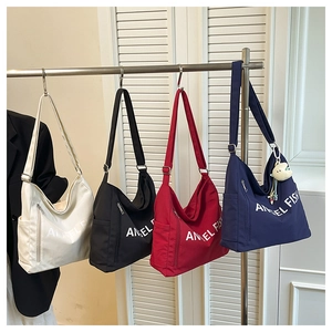 Detail view of multi-color nylon tote bags with Angel Fish print on a hanging display