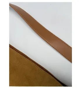 Vue détaillée des coutures renforcées sur la poignée du sac rétro marron et texture daim