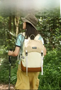 Outdoor color-block backpack with buckle closure shown in a forest lifestyle setting