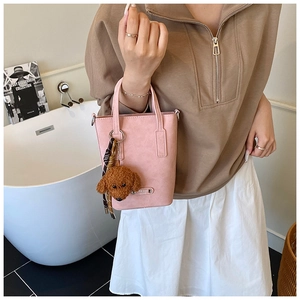Pink minimalist crossbody phone bag with cute brown teddy bear plush keychain accessory