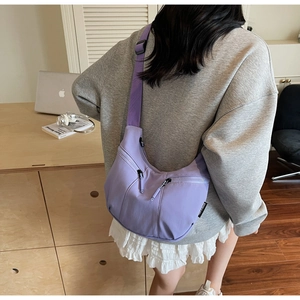 Gros plan du sac croissant en nylon violet clair avec bandoulière réglable en décor décontracté