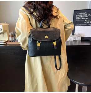 Close-up of black retro backpack featuring golden twist-lock closure and leather texture