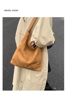 Gros plan sur un grand sac cabas en cuir mat marron porté par un mannequin en extérieur