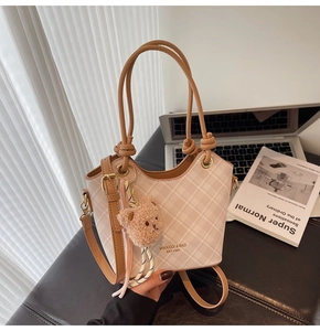 Borsa a secchiello a scacchi beige con manici in pelle marrone e ciondolo a forma di orso