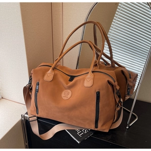 Detailed view of caramel large capacity travel bag with leather logo and side zippers