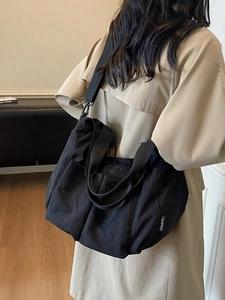 Large black waterproof nylon tote bag with wide shoulder strap for casual daily commuting
