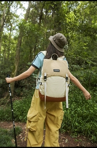Outdoor hiking backpack with khaki color blocking and fashion label in forest setting