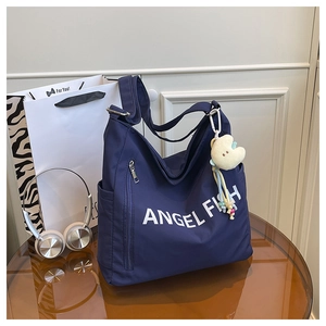 Detail of navy blue nylon tote bag with Angel Fish print and yellow star charm