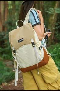 Outdoor backpack with three-color拼接 design and adjustable buckles shown in nature