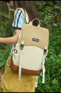Detail of color-block water-resistant backpack showing nylon fabric and fashion buckle