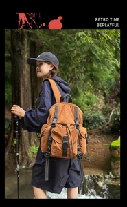 Mochila marrón de nailon para exteriores con diseño multibolsillo en un entorno forestal