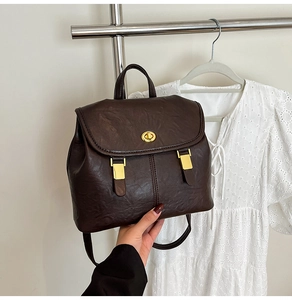 Detail view of dark brown oil wax leather backpack with golden turnlock and vintage handle