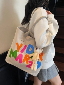 Off-white canvas tote bag with colorful letters and plush bear pendant for daily commuting