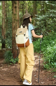 Outdoor hiking backpack in tricolor patchwork design shown in a lush forest setting
