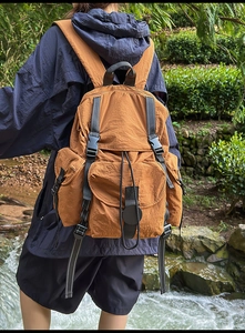 Detalle de la mochila de nailon resistente al agua color caramelo con hebillas estilo Yama