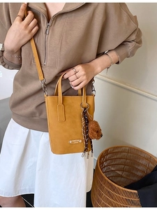 Mustard yellow crossbody phone bag with bear pendant and adjustable strap for women