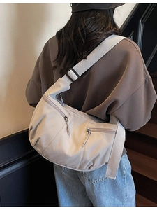 Sac à bandoulière beige en forme de croissant avec sangle large et poches zippées