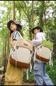 Detail of color-block water-resistant backpack with adjustable buckles in a forest setting