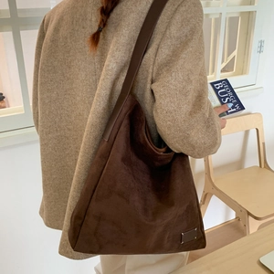 Detail view of deep brown matte hobo bag with thick texture and wide shoulder strap