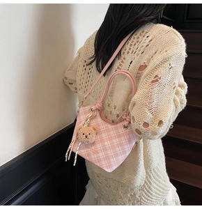 Dettaglio della borsa tote a quadretti rosa con ciondolo a orsetto e tracolla lunga