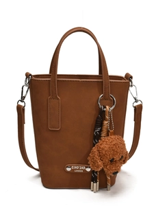 Brown faux leather crossbody bucket bag with adjustable strap and teddy bear charm