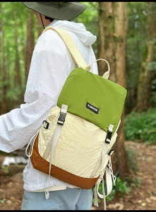 Detail of water-resistant hiking backpack showing color-block fabric and fashion label