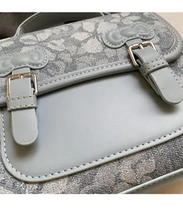 Close-up of floral jacquard fabric and bow-tie leather buckles on blue backpack