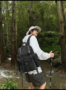 Foto al aire libre de una mochila táctica negra con correas plateadas en ruta de senderismo