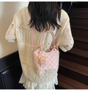 Borsa a secchiello rosa a quadretti con ciondolo a orsetto e logo dorato inciso
