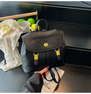 Close-up of black lychee grain faux leather backpack with gold buckle and top handle