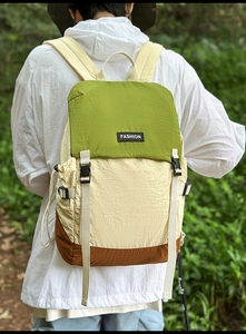 Detailed close-up of a three-color waterproof nylon backpack on a model in nature
