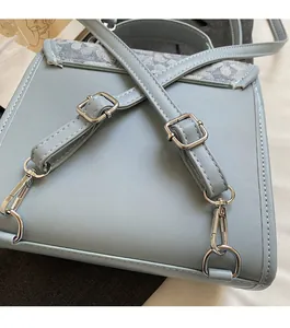 Detail of light blue leather bag featuring jacquard patterned flap and silver hardware