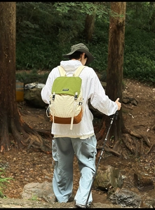 Outdoor backpack with three-color拼接 design and fashion label in a forest setting