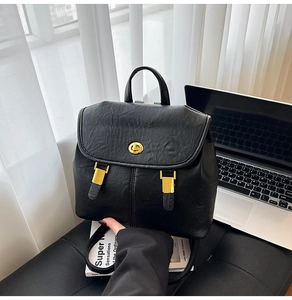 Detailed view of black vintage textured leather backpack with a gold turn-lock closure