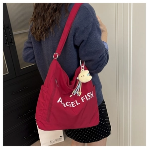 Close-up of red large capacity shoulder bag with Angel Fish print and yellow fish charm