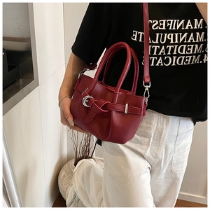 Détail du sac seau plissé bordeaux avec décoration à nœud et boucle métallique argentée