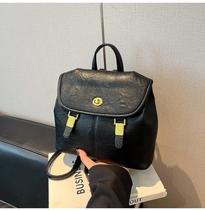 Close-up of black vintage leather backpack featuring elegant gold twist lock hardware