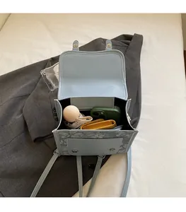 Top view of blue stylish backpack on grey jacket showing spacious interior capacity