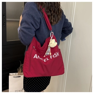 Detail of red canvas tote bag with Angel Fish print and cute plush cloud charm
