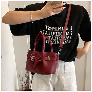 Vue détaillée du sac seau en cuir rouge foncé avec anneau métallique et bandoulière