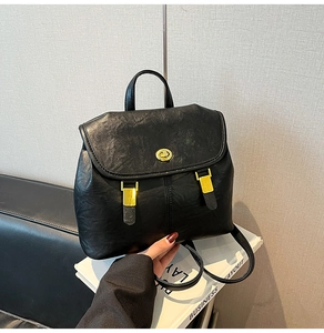 Close-up of black faux leather backpack with gold twist lock and fine grain texture