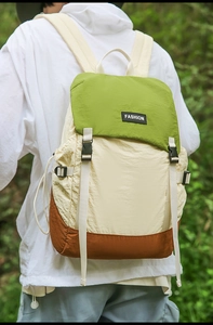 Three-color patchwork backpack in forest setting showing nylon fabric and fashion logo