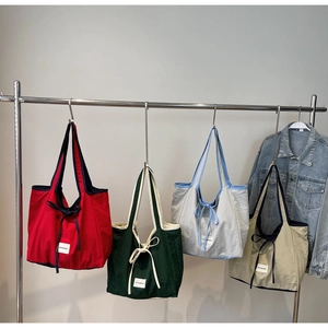Hanging nylon canvas tote bags in red, green, grey, and khaki with Love Morning tags