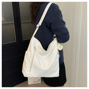 Detail of off-white large capacity shoulder bag with adjustable strap and chick charm