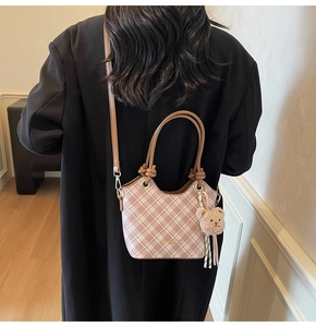 Borsa a secchiello a scacchi rosa e bianca con ciondolo a forma di orso vista da dietro