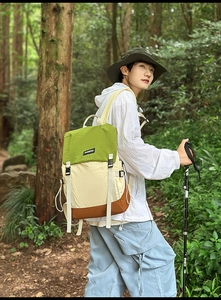 Outdoor waterproof backpack with green and beige color-block design and buckle detail